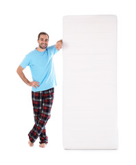 Wall Mural - Young man with comfortable mattress isolated on white