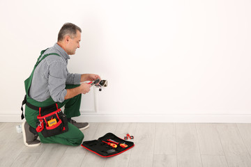 Poster - Professional electrician stripping wire ends indoors, space for text