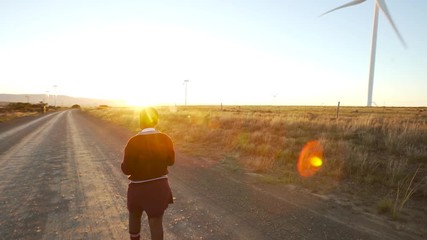 school girl walking on gravel road at dawn.