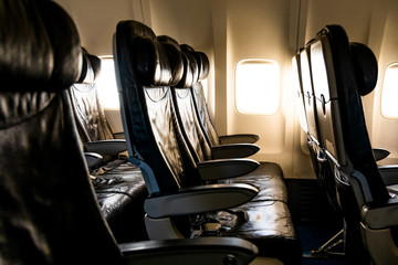 Empty airplane seats in the cabin in sunset light