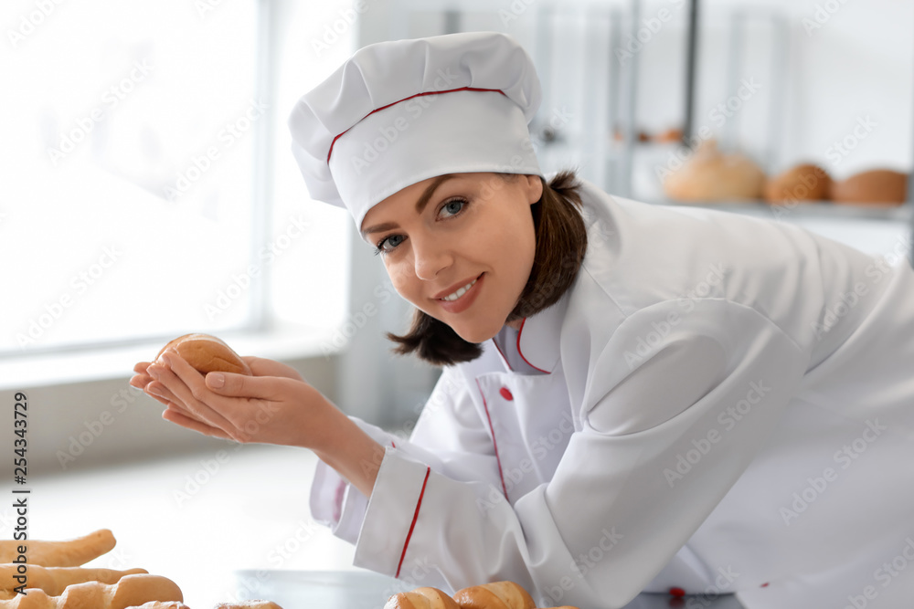 Female chef with freshly baked bakery products in kitchen