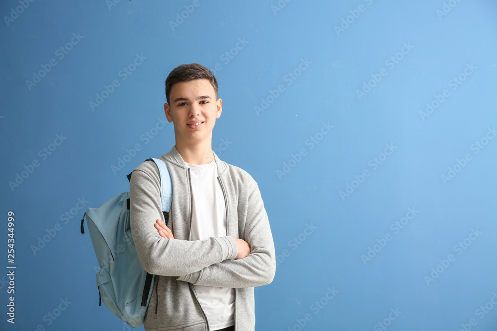Cute schoolboy on color background