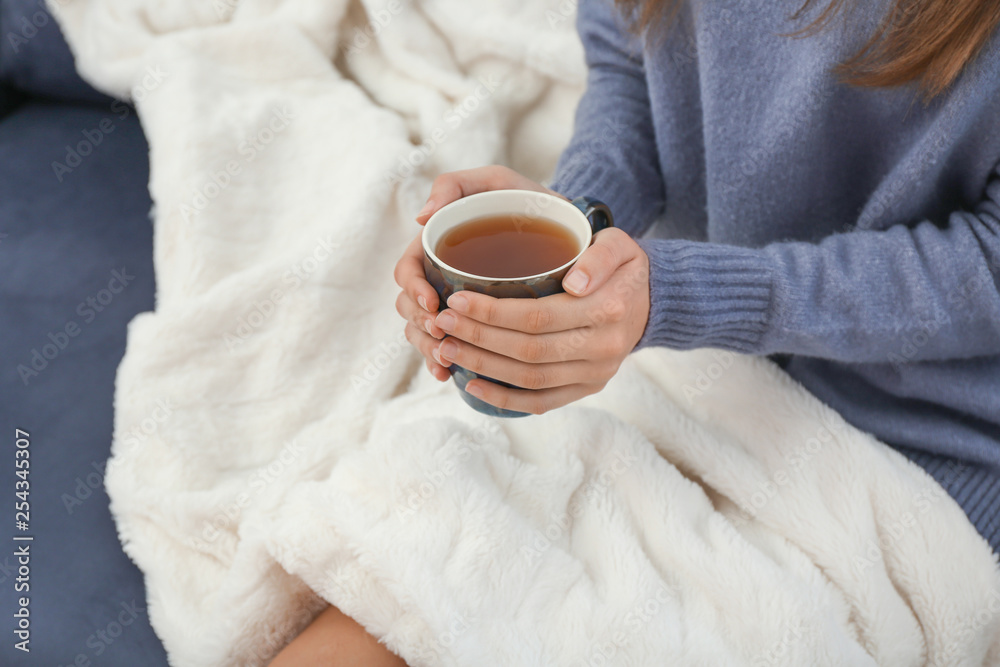 Young woman drinking hot tea at home