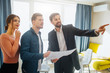 © estradaanton - Couple buy or rent apartment together. Realtor point forward. Couple look at that way. Positive and thoughtful. Business talk. Holding apartment plan.