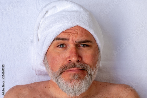 Fotografía Man prepared to receive a beauty treatment with an expression of strangeness or