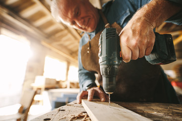 Wall Mural - Drilling a hole on wooden plank