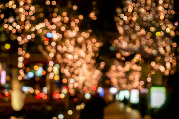 Wall Mural - Blurred and bokeh of LED refection lighting decorate on trees with city night life in Osaka, Japan.