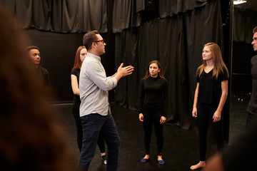 Wall Mural - Teacher With Male And Female Drama Students At Performing Arts School In Studio Improvisation Class