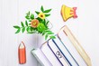 © kvitkanastroyu - Books, bookmark glasses, gingerbread pencil and yellow bell, chrysanthemum on a white wooden background
