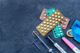 Fototapeta Dmuchawce - Choosing method of contraception : Birth control pills, an injection syringe, condom, IUD-method, on grey