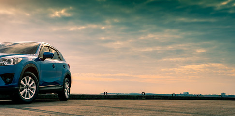 blue compact suv car with sport and modern design parked on concrete road by the sea. hybrid and ele