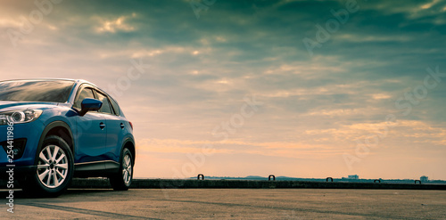 Fotomural Blue compact SUV car with sport and modern design parked on concrete road by the sea