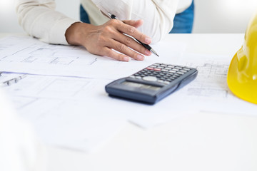 Wall Mural - Close-up Of Person's engineer Hand Drawing Plan On Blue Print with architect equipment, Architects discussing at the table, team work and work flow construction concept