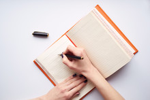 Woman's Hand Writing Notes In Diary