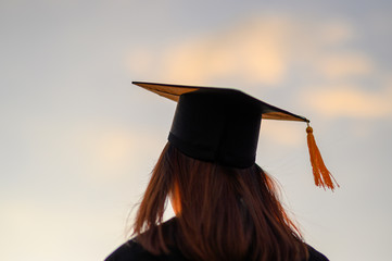 Wall Mural - Graduates wear a black dress, black hat at the university level.