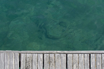 Emerald green water and wood boardwalk background texture