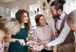 © Halfpoint - Multigeneration family putting food on plates on a indoor family birthday party.