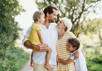 Wall Mural - A portrait of young family with small children in sunny summer nature.