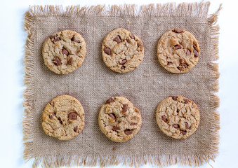 Wall Mural - Chocolate chip cookies isolated on brown sackcloth background.