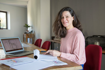 Smiling lady interior designer working in home office