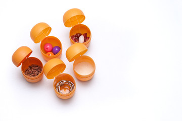 Handmade toy for hearing development. Plastic containers with buckwheat, beans, beads, semolina on white background