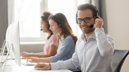 Wall Mural - smiling male call center operator in headset looking at camera
