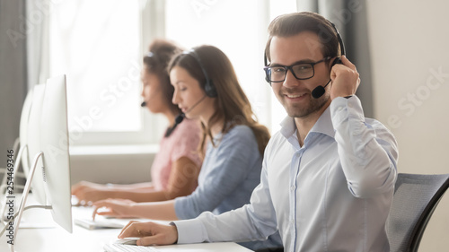 Fotografía Smiling male call center operator in headset looking at camera
