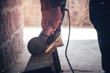 Wall Mural - Man cuts metal with a grinder. Industrial concept