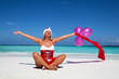© Avatar_023 - Beautiful woman in Santa Claus costume sitting on the beach