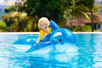 Wall Mural - Child in swimming pool. Kid on inflatable float