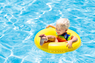 Canvas Print - Child in swimming pool on toy ring. Kids swim.