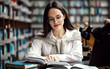 © proimagecontent - Cheerful dark haired student smiling while sitting at desktop with many studying books for exam preparation