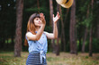 Joyful young woman play with straw hat, fun in summer outdoors