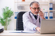 © Elnur - Aged male doctor working in the clinic