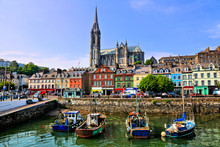 Colorful Buildings And Old Boats With Cathedral In Background In The Harbor Of Cobh, County Cork, Ireland