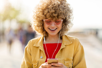 Wall Mural - Young woman with mobile phone in the city