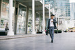 © LUMINA IMAGES - Middle-aged Asian businessman walking outdoors and looking at his watch.