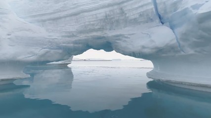 Wall Mural - Iceberg Arch Antarctica Ocean Glacier Seascape. Hole in Massive Iceberg Floating in Arctic Blue Water Sea at Greenland. Double Crystal Cave Bridge at North Landscape Shot Footage 4K (UHD)