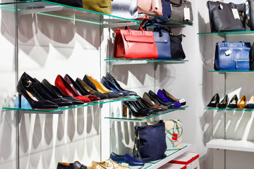 Shelves with beautiful  leather shoes and bags in store