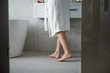 © Yakobchuk Olena - Young barefoot lady in bathroom near washstand