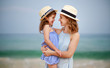 © JenkoAtaman - happy family at beach. mother and child daughter hug at sea.