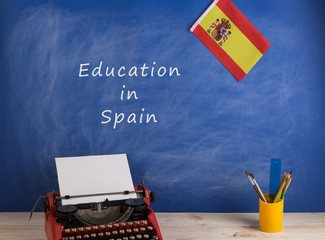 Fototapete - Education concept - red typewriter, flag of Spain and blackboard with text 