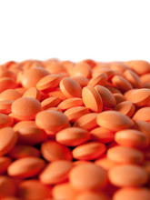 A Pile Of Small Orange Pills Isolated On White Background