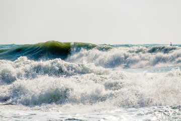 Strong and dangerous storm in the Black sea. Beautiful and large storm surge in the Bay of Gelendzhik in Gelendzhik. sea foam, wave crests, clear green water. 