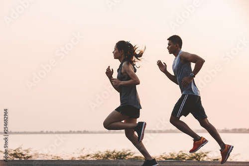 Fotomural young couple runner running on running road in city park