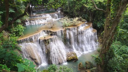 Wall Mural - Waterfall flow standing with forest enviroment from high angle view in thailand, called Huay orHuai mae khamin in Kanchanaburi Provience, Zoom out.