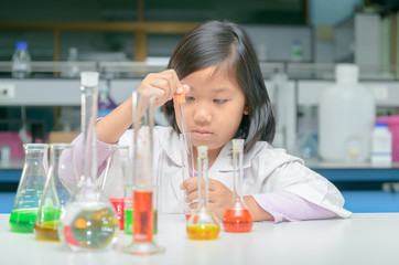 Wall Mural - little scientist in lab coat making experiment