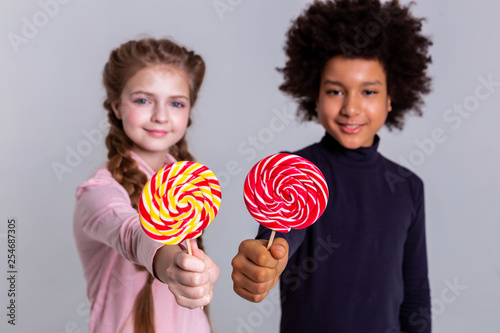 Resolute Smiling Kids Pulling Out Hands And Showing Multicolored