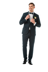 Wall Mural - happy bridegroom in elegant black suit with boutonniere isolated on white