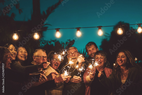 Fotografía Happy family celebrating with sparkler at night party outdoor - Group of people